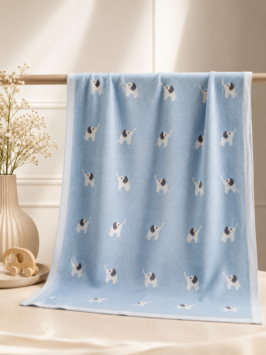 Blue blanket with dog pattern on a light wooden surface